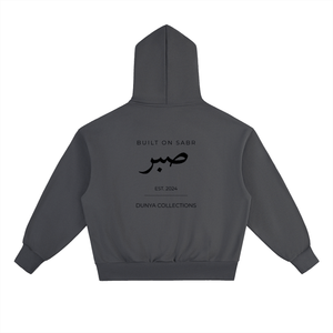 Back view of charcoal grey Sabr oversized fleece hoodie with black Arabic calligraphy and Dunya Collections branding